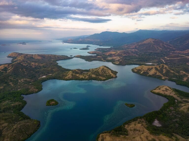 Panorama Pulau Padar di Labuan Bajo dengan perbukitan dan teluk biru dilihat dari udara