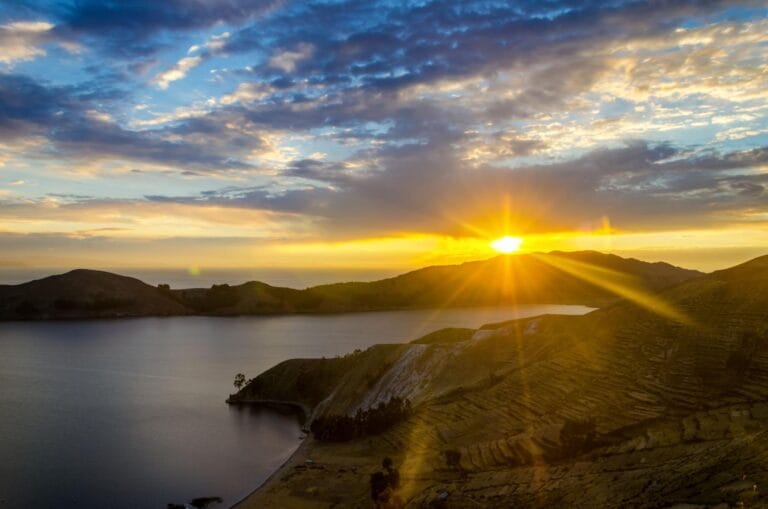 Pemandangan sunrise di Pulau Padar dengan cahaya matahari pagi dan bukit savana