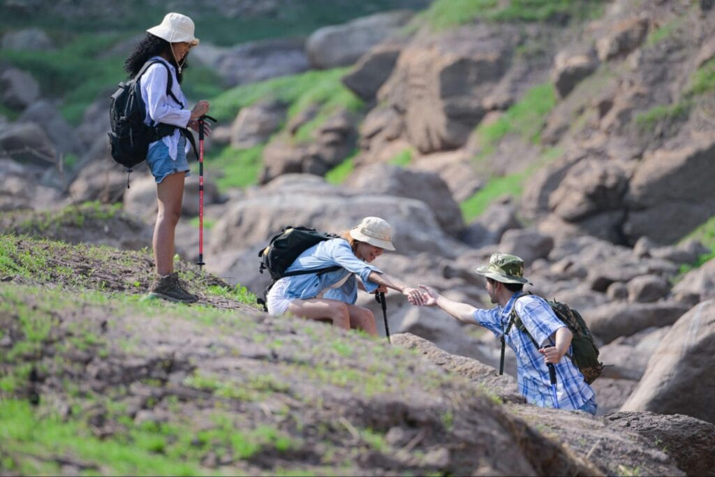 Wisatawan saling membantu saat trekking sebagai contoh tips trekking aman dan nyaman di Pulau Padar
