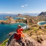 Pemandangan Pulau Padar dari puncak bukit dengan wisatawan duduk menikmati panorama tiga teluk di Taman Nasional Komodo