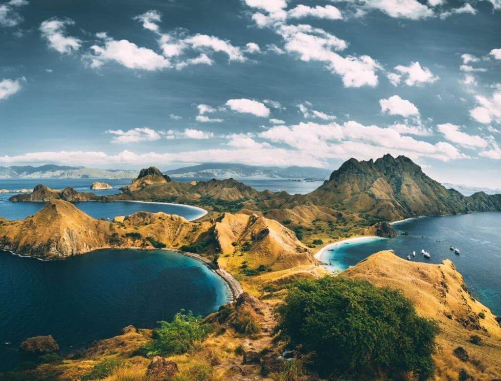 Panorama spot foto terbaik di Pulau Padar dengan kombinasi bukit savana, laut biru, dan tiga pantai berwarna