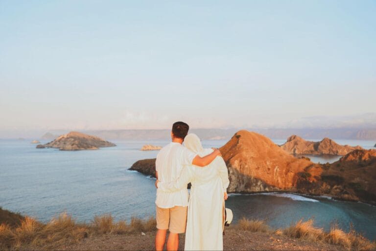 Tips foto dengan HP di Pulau Padar menampilkan panorama laut biru dan perbukitan dari sudut pandang puncak saat cahaya alami lembut