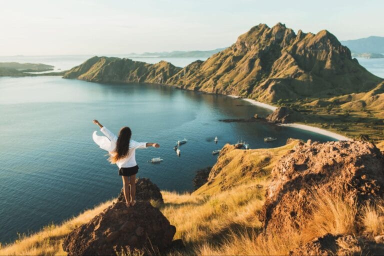 wisatawan menikmati panorama Pulau Padar dari puncak bukit dengan suasana tenang dan sepi